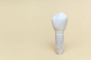 Zirconia dental implant and crown against neutral background
