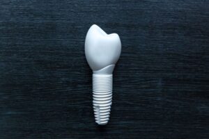 Zirconia dental implant and crown against dark background