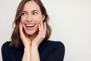 Smiling woman touching sides of her face